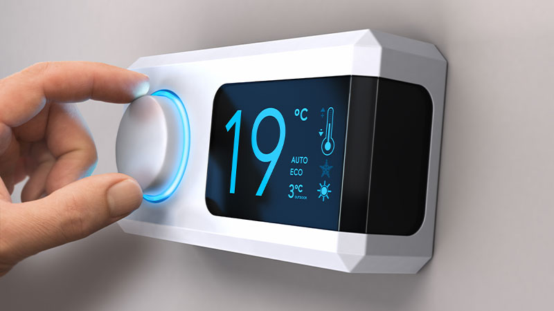 close-up mano che usa termostato